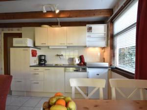 't ZandにあるHoliday Home in t Zand close to the Dutch coastのキッチン(白いキャビネット、フルーツテーブル付)