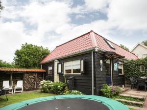 ein Haus mit einem Trampolin im Hof in der Unterkunft Holiday Home in t Zand close to the Dutch coast in 't Zand