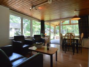 a living room with a couch and a table and chairs at Holiday Home in Stramproy near Nature Reserve in Stramproy