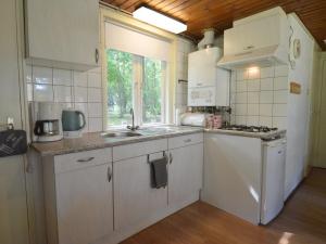 a kitchen with white cabinets and a sink and a window at Holiday Home in Stramproy near Nature Reserve in Stramproy