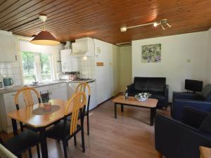 a kitchen and a living room with a table and chairs at Holiday Home in Stramproy near Nature Reserve in Stramproy +24 photos
