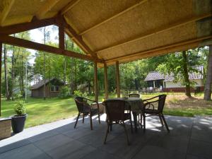 a patio with a table and chairs under a pavilion at Holiday Home in Stramproy near Nature Reserve in Stramproy