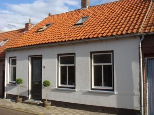 Biały dom z pomarańczowym dachem w obiekcie Spacious holiday home in Groede w mieście Groede
