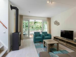 a living room with a blue chair and a fireplace at Luxurious Apartment in Koudekerke near Beach in Koudekerke