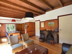 sala de estar con chimenea, mesa y sillas en Detached holiday home surrounded by nature en Zuidwolde
