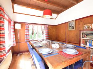 een eetkamer met een houten tafel en stoelen bij Detached holiday home surrounded by nature in Zuidwolde