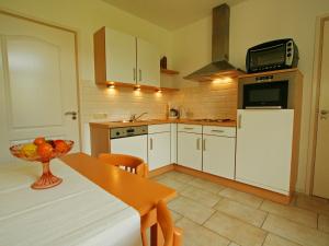 a kitchen with white cabinets and a table and a microwave at Farmstay with Garden Views in Stokhem