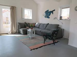 a living room with a couch and a table at Cozy family home directly behind the dunes in Dishoek