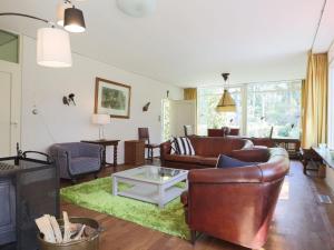 ein Wohnzimmer mit einem Sofa und einem Tisch in der Unterkunft Beautiful Holiday Home with Garden in Huijbergen in Huijbergen