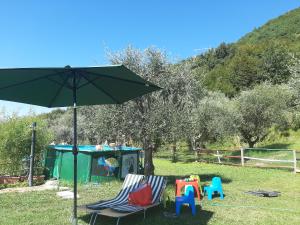 un grupo de sillas y un paraguas en un patio en Agriturismo Conte Brunello, en Saló