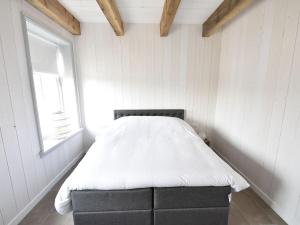 a bed in a white room with a window at Holiday Home in Holland near Beaches in Callantsoog