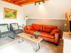 uma sala de estar com um sofá de couro e uma mesa em Modern Holiday Home in Friesland by the Lake em Anjum