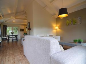 ein Wohnzimmer mit einem weißen Sofa und einem Tisch in der Unterkunft Holiday home in the Veluwe in nature in Putten