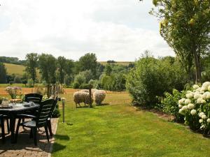 a patio with a table and sheep in a field at Restored farmhouse in Wijlre with two terraces in Wijlre