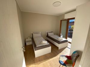 a small bedroom with two beds and a mirror at Appartamento Golfo Borromeo 1 Baveno in Baveno