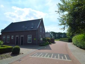 a red house with a black roof on a brick road at Luxury apartment in Posterholt with a terrace in Posterholt