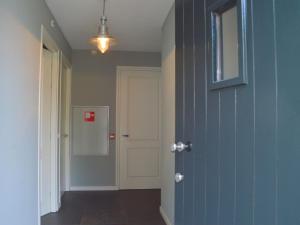 un pasillo vacío con una puerta azul y una puerta blanca en Luxury apartment in Posterholt with a terrace, en Posterholt