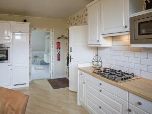 a kitchen with white cabinets and a stove top oven at Boutique Apartment in Ritthem with Terrace in Ritthem