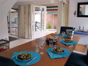 een houten tafel met borden eten en wijnglazen bij Lovely Holiday Home in Noordwijkerhout near Lake in Noordwijkerhout