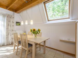 a dining room with a table and chairs and a window at Comfortable holiday home in Nunspeet in Nunspeet