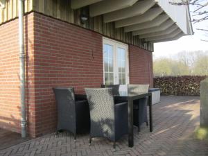 a patio with a table and chairs on a brick building at Rural holiday home in Well with garden in Knikkerdorp