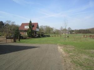 a dirt road in front of a house at Rural holiday home in Well with garden in Knikkerdorp