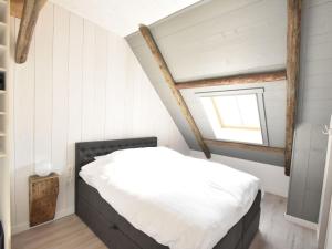 a bedroom with a bed and a window at Apartment Hazenborgh near the coast in Callantsoog in Callantsoog