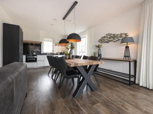 cocina y comedor con mesa y sillas en Luxury villa with a sauna, at the Tjeukemeer, en Delfstrahuizen