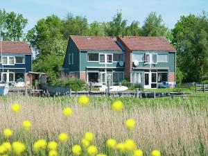 a couple of houses in a field with yellow flowers at Delightful Holiday Home in Warns with Jetty in Warns