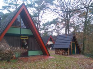 un groupe de trois maisons dans un champ dans l'établissement Cosy Holiday Home in Limburg with Forest nearby, à Stramproy
