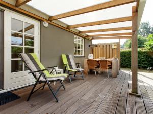 a patio with chairs and a table on a deck at Holiday home large play sun meadow in Ravenstein