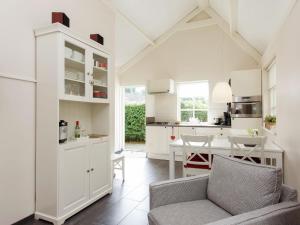 a kitchen and dining room with white cabinets and a table at Holiday home large play sun meadow in Ravenstein