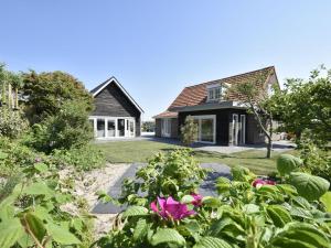 ein Haus mit Garten davor in der Unterkunft Lavish Villa in Julianadorp aan zee with Sauna in De Zandloper