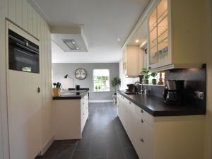 een keuken met witte kasten en zwarte aanrechtbladen bij Lavish Villa in Julianadorp aan zee with Sauna in De Zandloper