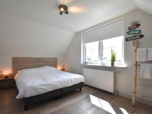 ein Schlafzimmer mit einem großen Bett und einem Fenster in der Unterkunft Lavish Villa in Julianadorp aan zee with Sauna in De Zandloper