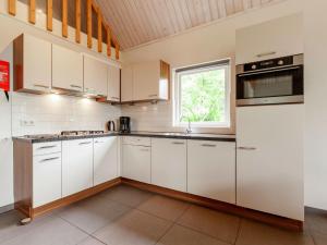 een keuken met witte kasten en een raam bij Rural holiday home in Vessem with a sauna in Vessem