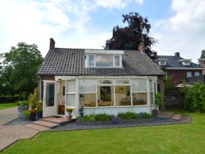 a detached house with a conservatory and lawn at Attractive holiday home in Soerendonk in Soerendonk