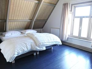 ZoutkampにあるFisherman s house near the Lauwersmeerのベッドルーム1室(ベッド2台、窓付)