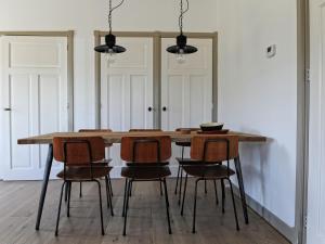 a dining room with a wooden table and chairs at Fisherman s house near the Lauwersmeer in Zoutkamp