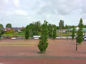 un parque con una fila de árboles y bancos en Fisherman s house near the Lauwersmeer, en Zoutkamp