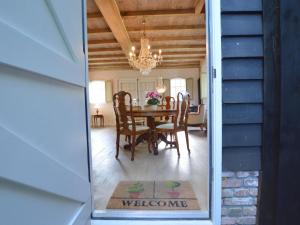 uma sala de jantar com uma mesa e cadeiras e um lustre em Cozy Holiday Home in Volkel with Sauna em Volkel