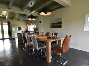 een eetkamer met een houten tafel en stoelen bij Quaint Villa in Tzummarum with Garden Terrace in Tzummarum