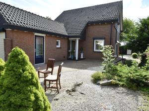 une maison avec deux chaises devant elle dans l'établissement Holiday home in Zeeland with wide views, à Bruinisse