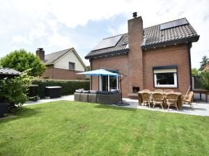 un patio trasero con sillas, una mesa y una casa en Holiday home in Zeeland with wide views, en Bruinisse