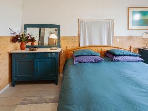 a bedroom with a blue bed with two pillows at Characteristic head neckhull farm with rowing boat in Burum