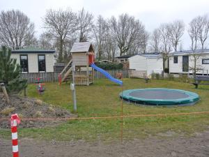 een tuin met een speeltuin met een trampoline bij Charming Chalet in Goedereede with Open Area in Goedereede