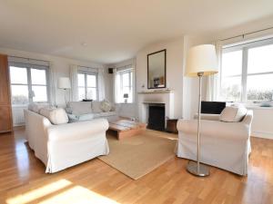 uma sala de estar com mobiliário branco e uma lareira em Beautiful villa on Terschelling in the dunes 150 meters away em Midsland aan Zee