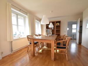 a dining room with a wooden table and chairs at Beautiful villa on Terschelling in the dunes 150 meters away in Midsland aan Zee