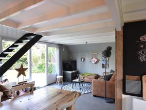 ein Wohnzimmer mit einem Sofa und einem Tisch in der Unterkunft Balmy Holiday Home in Tuitjenhorn with Fenced Garden in Tuitjenhorn
