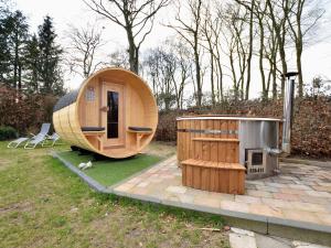 uma sauna e uma casa de hobbit num quintal em Holiday home with covered porch and sauna em Voorthuizen